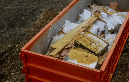 Roxa Demolition junk removal truck with construction debris and wood waste on job site